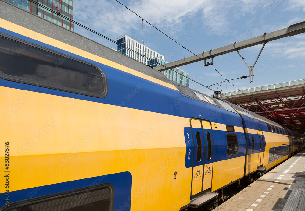 Dutch double decker train is leaving a station