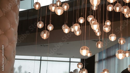 Lights of modern chandelier. Close up. Steadicam shot.