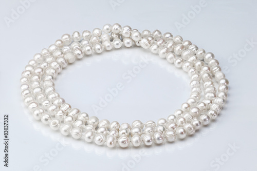 necklace of pearls on a white glossy background