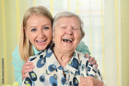 Senior woman with her caregiver. Happy and smiling.