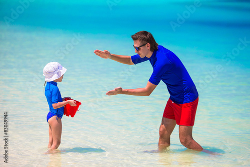 Happy father and little daughter have fun on tropical beach