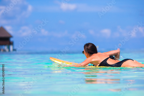 Young surfer woman surfing during beach vacation © travnikovstudio