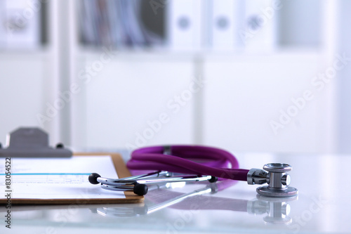 Doctor&#39;s stethoscope  with folder on the desk photo