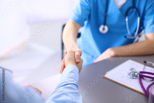Doctor shakes hands with a patient isolated on white background