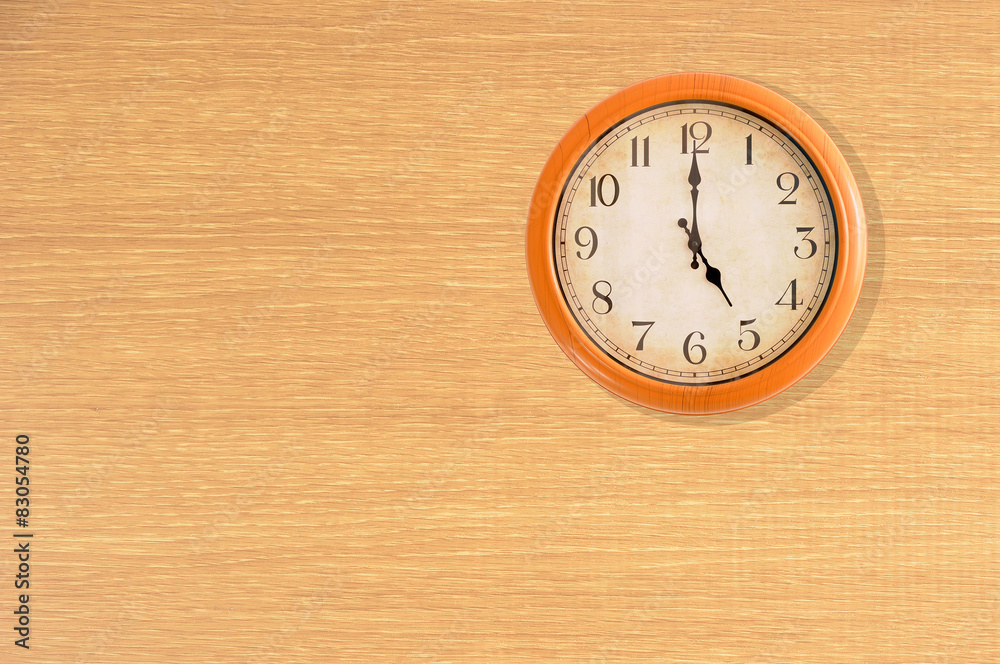 Clock showing 5 o'clock on a wooden wall Clock showing 5 o'clock on a wooden wall