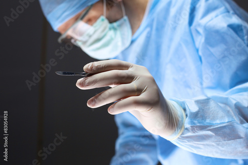 Canvastavla Man surgeon holds a scalpel in an operating room