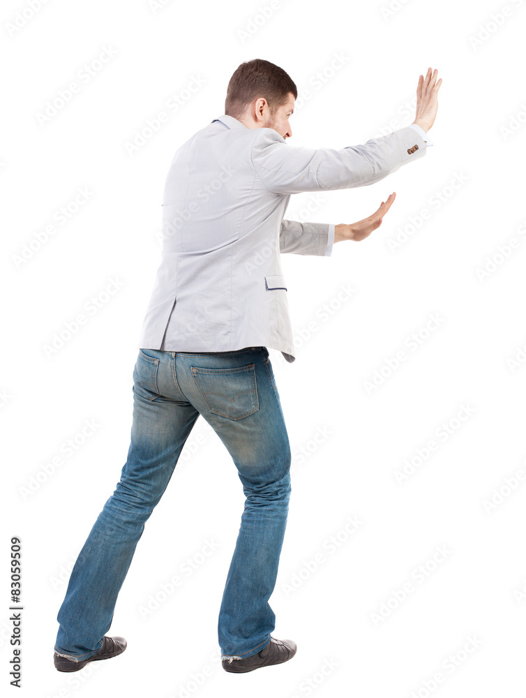 back view of business man pushes wall. back view of business man pushes wall.