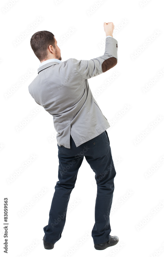 back view of standing man pulling a rope from the top or cling t back view of standing man pulling a rope from the top or cling t