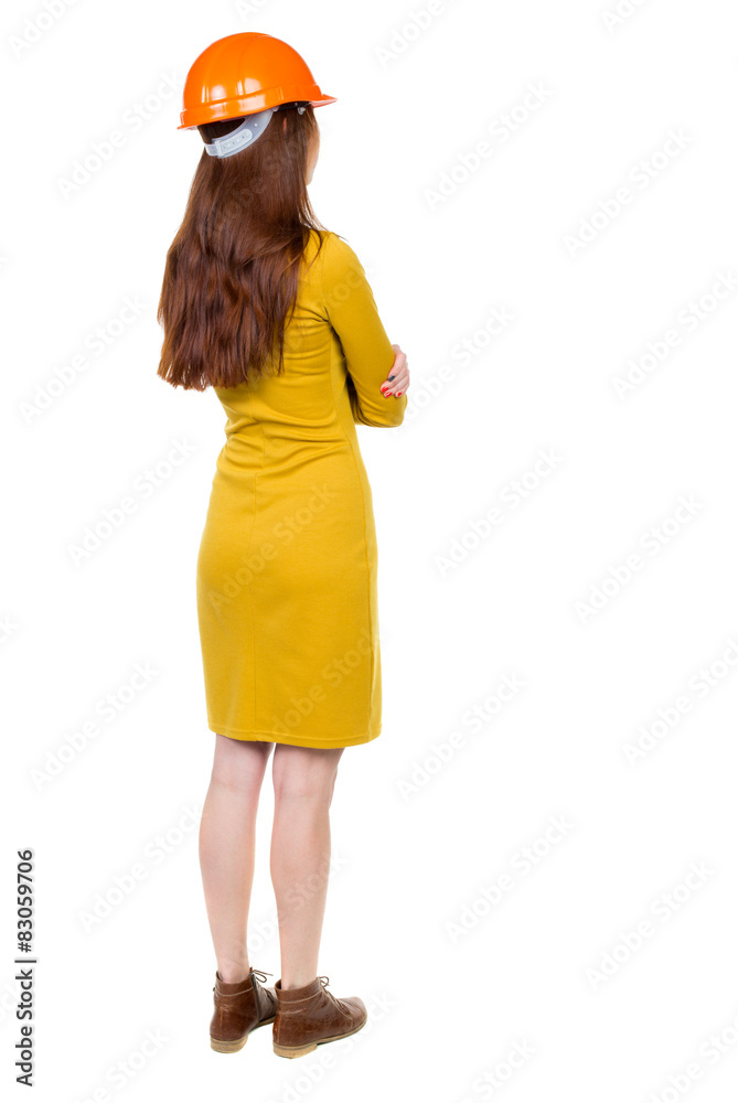 Backview of an woman engineer in construction helmet stands Backview of an woman engineer in construction helmet stands