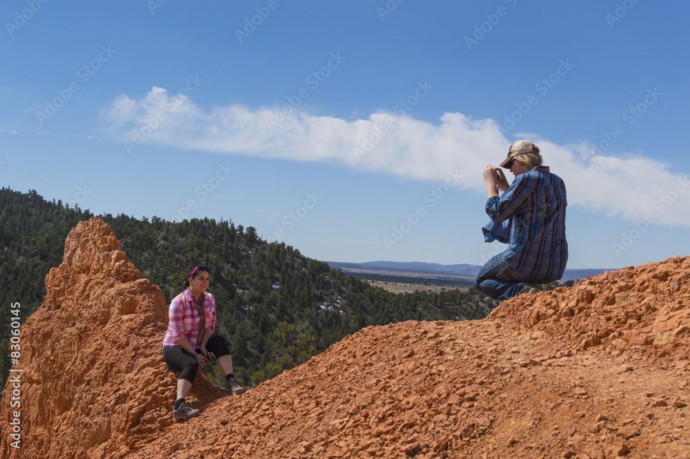 A young man photographs a young woman in Red Canyon Utah
