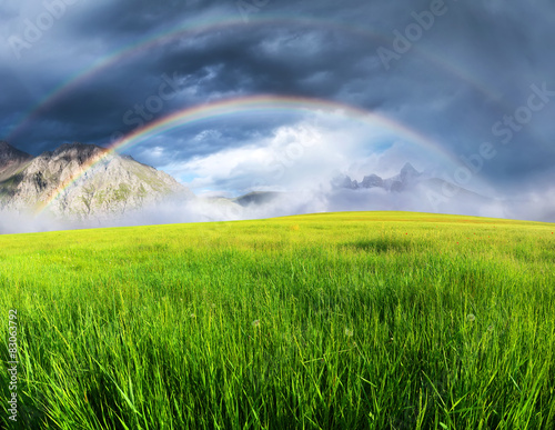 Rainbow in the mountain valley. Beautiful summer landscape