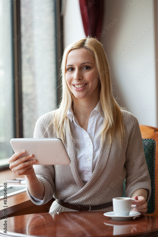 Happy young woman using digital tablet in cafe Happy young woman using digital tablet in cafe