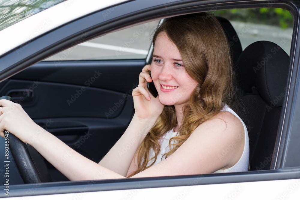 woman with the phone behind the wheel of car