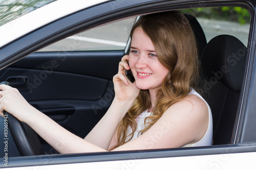 woman with the phone behind the wheel of car