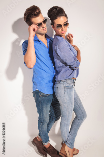 Side view of a casual couple posing near a wall