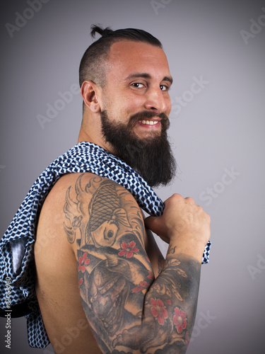 Hipster con brazo tatuado y polo al hombro photo