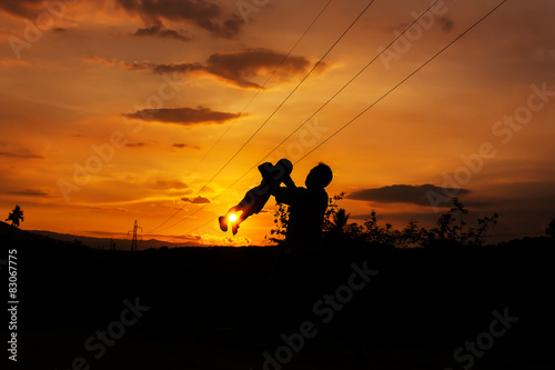 silhouettes of father and son play 