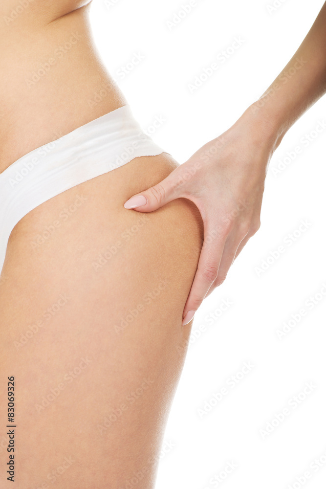 Slim woman pinching her buttocks.