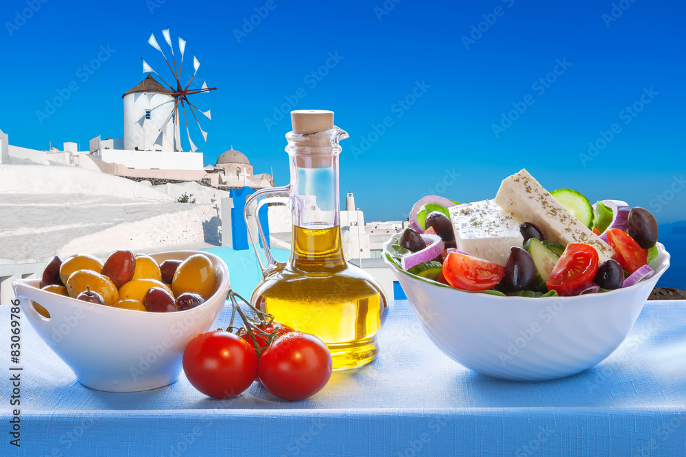 Greek salad against windmill in Santorini island, Greece - obrazy, fototapety, plakaty 