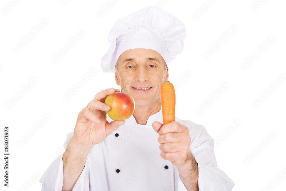 Male chef with an apple and carrot Male chef with an apple and carrot