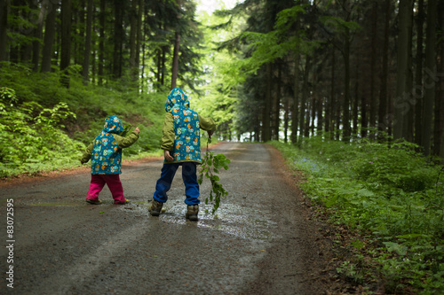 Two kids playing on the forrest road