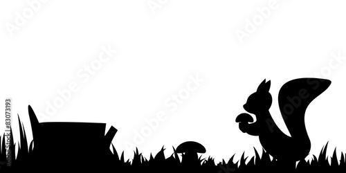 Silhouette of the squirrel in the grass.