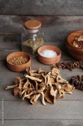 Dried mushrooms with spice on wooden background