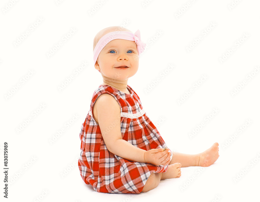 Portrait of happy little baby girl in the dress sitting on a whi Portrait of happy little baby girl in the dress sitting on a whi