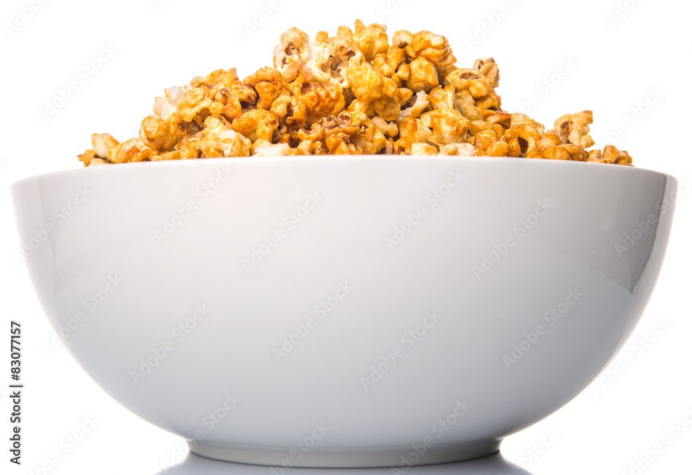 Caramel popcorn in white bowl over white background Caramel popcorn in white bowl over white background