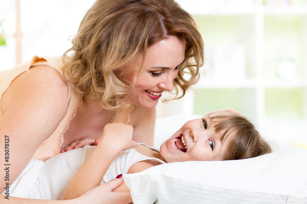 happy family - kid with mother play, laugh and tickle in white happy family - kid with mother play, laugh and tickle in white