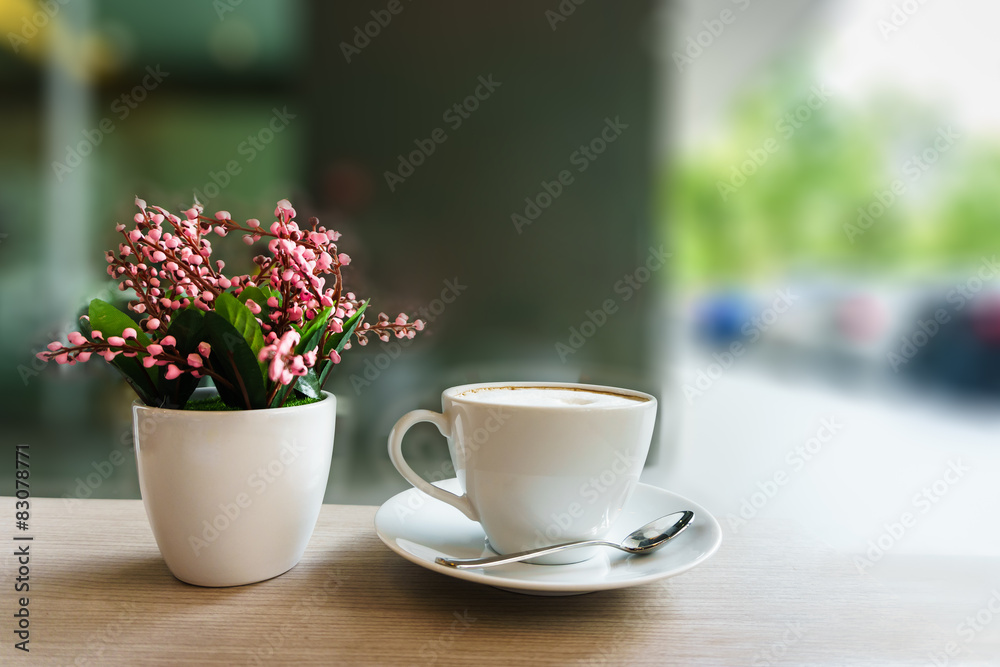 coffee cup and flower on wooden table in coffee shop coffee cup and flower on wooden table in coffee shop