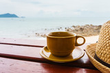 coffee cup on wooden table with sea background