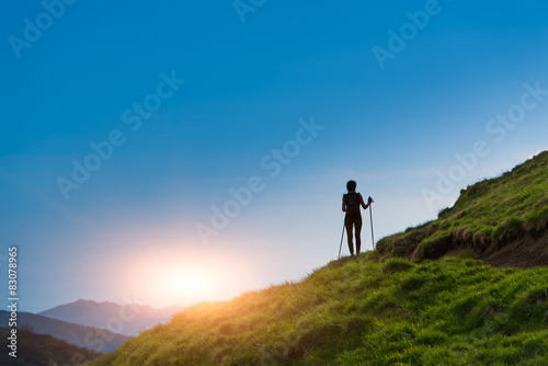 Silhouette of girl that makes trekking at sunset
