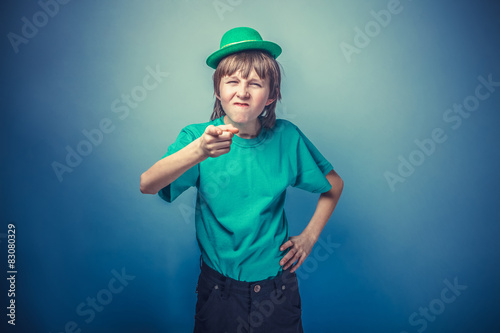 European-looking boy of ten years shows a finger at the camera, 