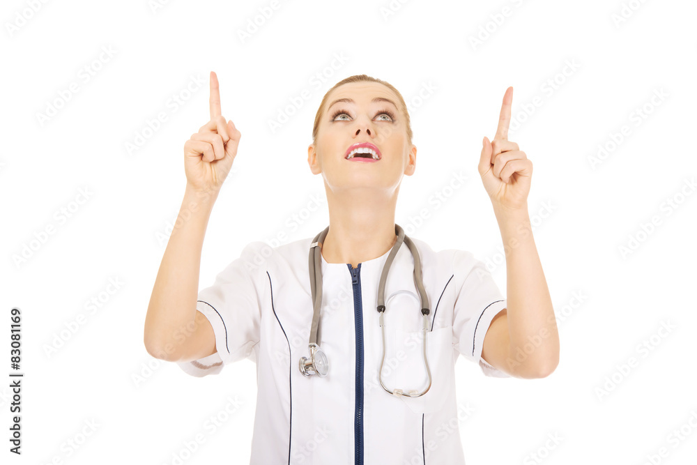 Medical doctor woman pointing up.