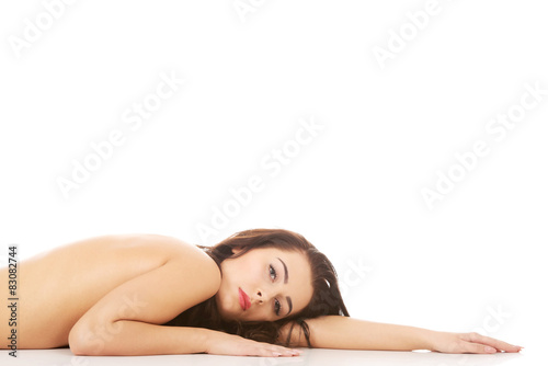 Beautiful naked woman lying on belly.