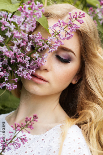 Portrait of beautiful girl with lilac flowers
