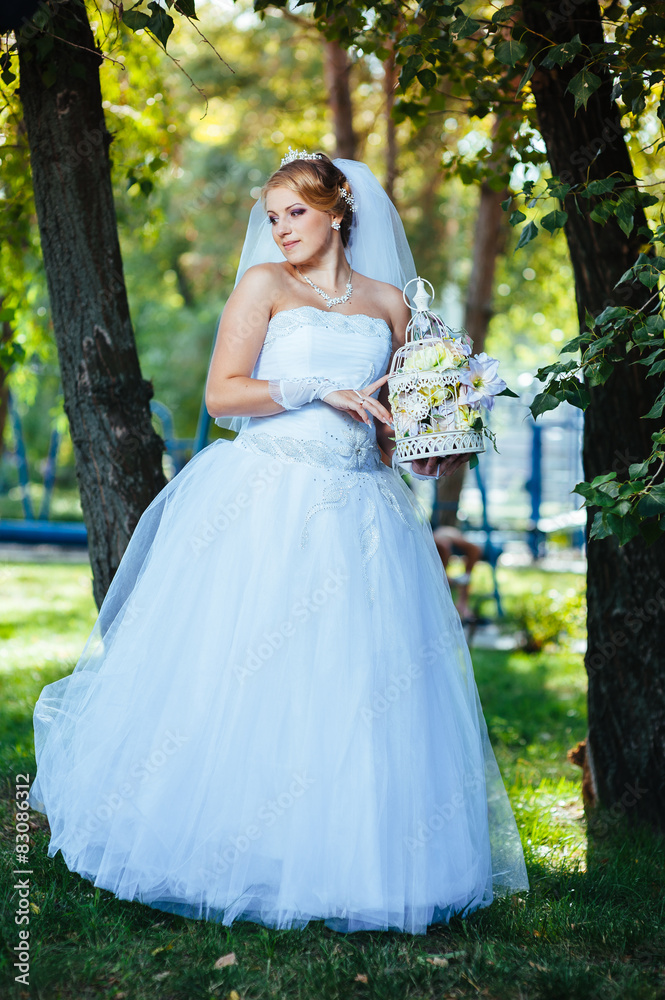Beautiful bride posing outdoor at the park in her wedding day Beautiful bride posing outdoor at the park in her wedding day