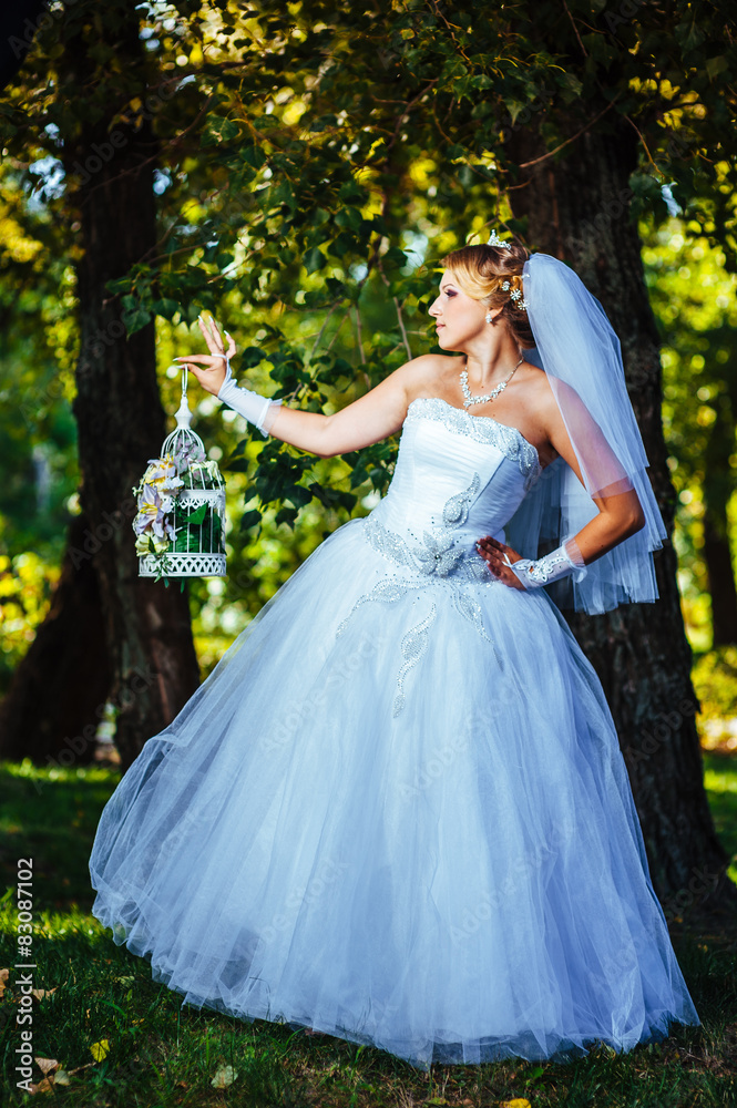 Beautiful bride posing outdoor at the park in her wedding day