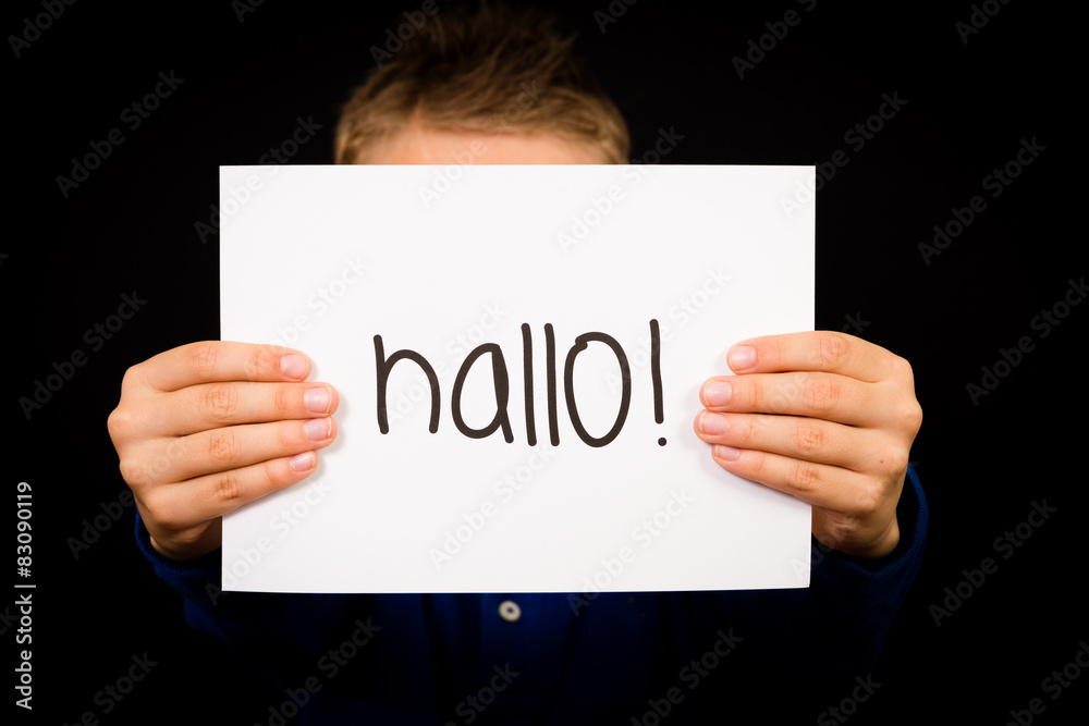 Child holding sign with German word Hallo - Hello in English Child holding sign with German word Hallo - Hello in English