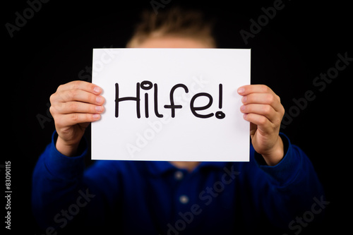 Child holding sign with German word Hilfe - Help