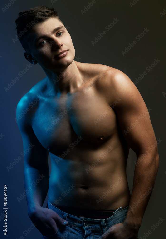 Handsome sexy young man with muscular body in jeans.