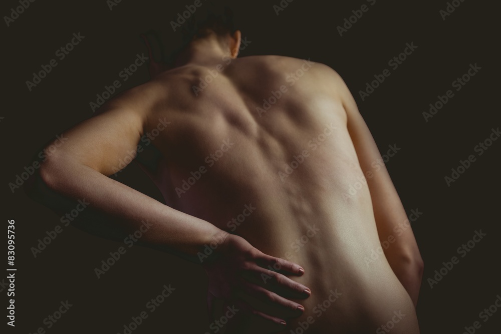 Nude woman with a back injury