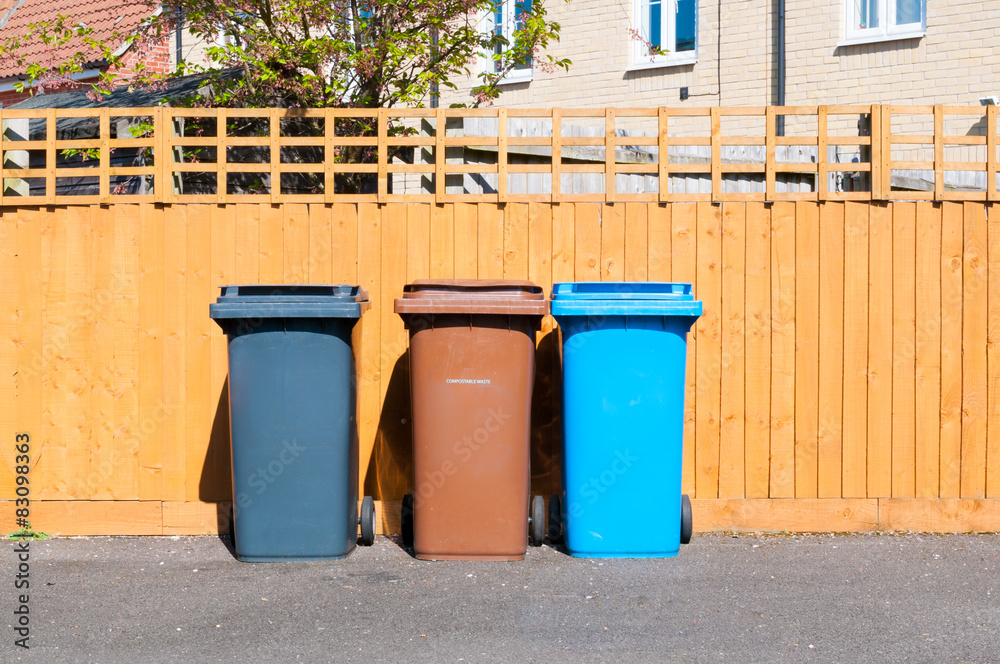 Three plastic waste bins outside a house Three plastic waste bins outside a house