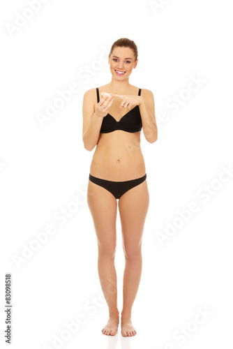 Woman applying cream moisturizer.
