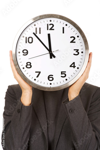 Woman covering face with clock.
