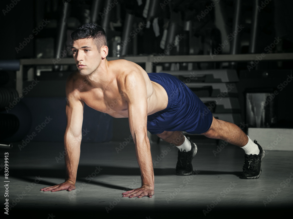 Fototapeta premium Muscular man in gym exercising