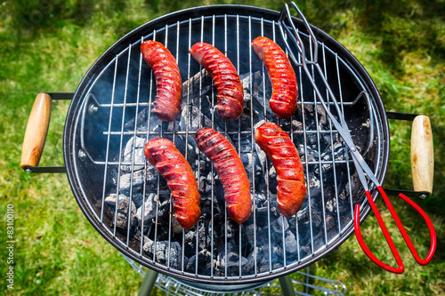 Red hot sausages with rosemary on garden grill