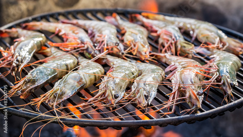Grilling fresh shrimps with lemon and parsley