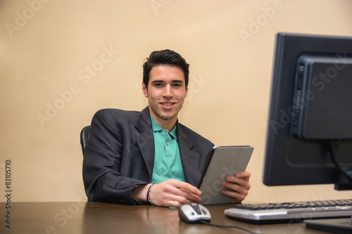 Wallpaper Mural Young man wearing business suit in office with tablet PC Torontodigital.ca